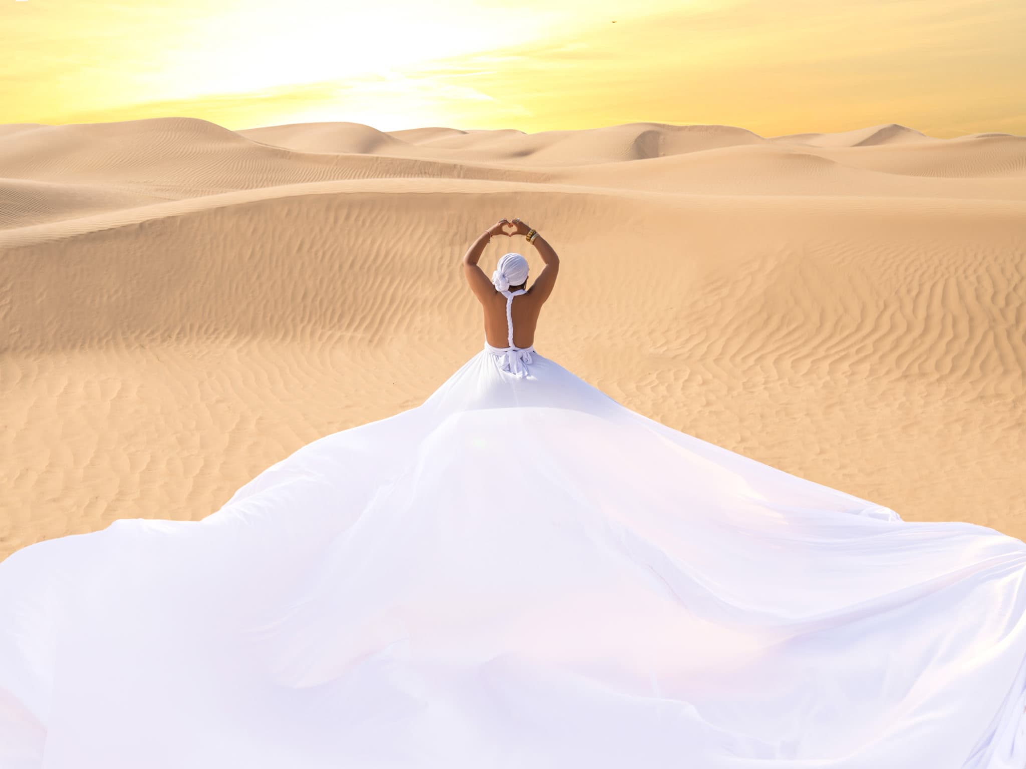 A woman at rest in the desert at sunrise